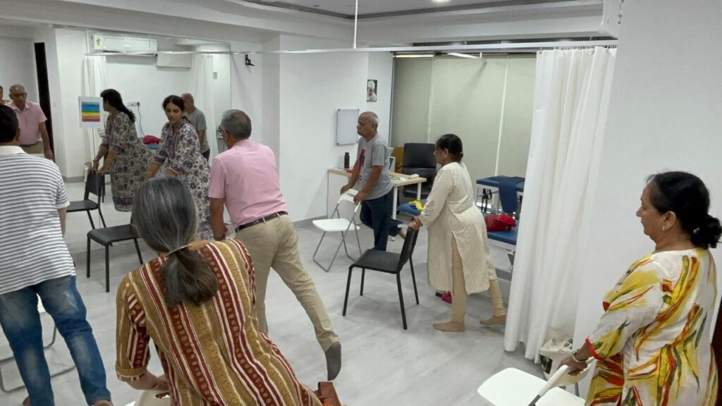 Dr Bindya teaching physiotherapy using chairs